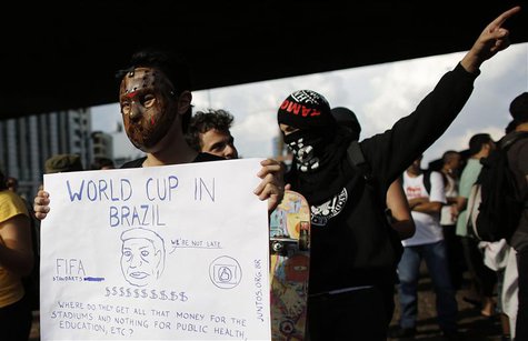 A man wearing a mask holds a banner during a protest against the 2014 World Cup, in Sao Paulo January 25, 2014. REUTERS/Nacho Doce A man wearing a mask holds a banner during a protest against the 2014 World Cup, in Sao Paulo January 25, 2014. REUTERS/Nacho Doce