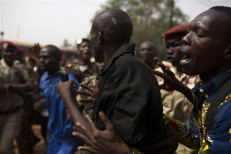 A man pushes a Gendarmerie officer (C) away from an angry crowd, moments before he manages to escape in the back of a vehicle after being ac A man pushes a Gendarmerie officer (C) away from an angry crowd, moments before he manages to escape in the back of a vehicle after being ac