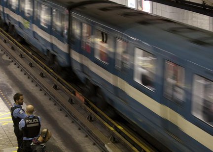 Police officers watch a train pass in a subway station in Montreal, May 10, 2012. Montreal's metro was shut down this morning after smoke bo Police officers watch a train pass in a subway station in Montreal, May 10, 2012. Montreal's metro was shut down this morning after smoke bo