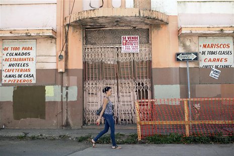 A woman walks past a closed restaurant in Ponce, on Puerto Rico's southern coast, February 5, 2014. REUTERS/Alvin Baez A woman walks past a closed restaurant in Ponce, on Puerto Rico's southern coast, February 5, 2014. REUTERS/Alvin Baez