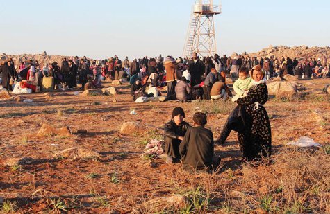 Syrian refugees, fleeing the violence in Syria, wait to enter Turkey on the Syrian-Turkish border in Shamm Alqrain village, northern country Syrian refugees, fleeing the violence in Syria, wait to enter Turkey on the Syrian-Turkish border in Shamm Alqrain village, northern country