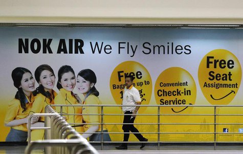 A Nok Air staff member walks past a commercial for the airlines at Don Muang International Airport in Bangkok June 20, 2013. REUTERS/Chaiwat A Nok Air staff member walks past a commercial for the airlines at Don Muang International Airport in Bangkok June 20, 2013. REUTERS/Chaiwat