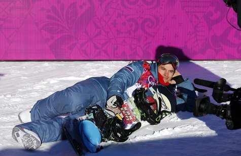 Russia's Alexey Sobolev poses lying in the snow at the finish line during the men's slopestyle snowboarding qualifying session at the 2014 S Russia's Alexey Sobolev poses lying in the snow at the finish line during the men's slopestyle snowboarding qualifying session at the 2014 S