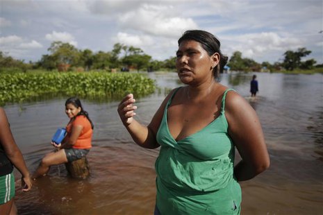 A woman speaks along a flooded street on the outskirts of Trinidad, some 400 km (249 miles) northeast of La Paz February 5, 2014. REUTERS/Da A woman speaks along a flooded street on the outskirts of Trinidad, some 400 km (249 miles) northeast of La Paz February 5, 2014. REUTERS/Da