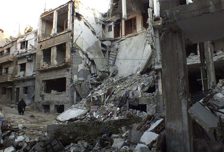 A man walks along a street lined with damaged buildings in the besieged area of Homs February 5, 2014. REUTERS/Yazan Homsy A man walks along a street lined with damaged buildings in the besieged area of Homs February 5, 2014. REUTERS/Yazan Homsy
