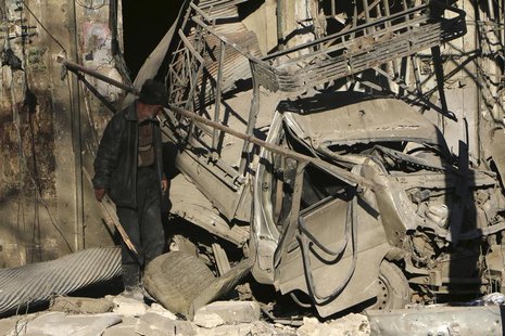 A man looks at a damaged pick-up truck at a site hit by what activists said was shelling by forces loyal to Syria's President Bashar al-Assa A man looks at a damaged pick-up truck at a site hit by what activists said was shelling by forces loyal to Syria's President Bashar al-Assa