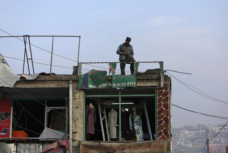 An Afghan policeman stands guard on the roof of a shop damaged in a suicide attack in Kabul January 26, 2014. REUTERS/Mohammad Ismail An Afghan policeman stands guard on the roof of a shop damaged in a suicide attack in Kabul January 26, 2014. REUTERS/Mohammad Ismail