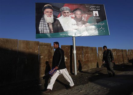 Men walk past a campaign banner of Afghan presidential candidate Abdul Rassoul Sayyaf, in Kabul February 9, 2014.REUTERS/Mohammad Ismail Men walk past a campaign banner of Afghan presidential candidate Abdul Rassoul Sayyaf, in Kabul February 9, 2014.REUTERS/Mohammad Ismail