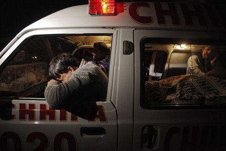 A relative (L) mourns his family member, who was killed by unknown gunmen, next to his body in an ambulance, outside the Civil Hospital morg A relative (L) mourns his family member, who was killed by unknown gunmen, next to his body in an ambulance, outside the Civil Hospital morg
