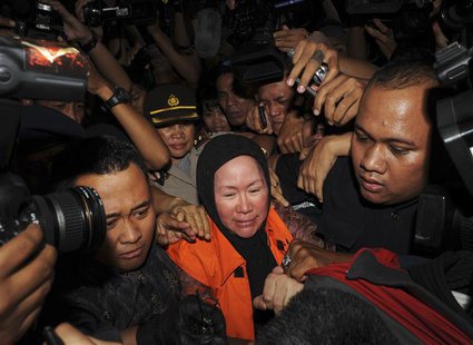 Banten governor Ratu Atut Chosiyah (C), wearing an KPK orange vest, walks as she is detained at the national anti-graft agency (KPK) office Banten governor Ratu Atut Chosiyah (C), wearing an KPK orange vest, walks as she is detained at the national anti-graft agency (KPK) office