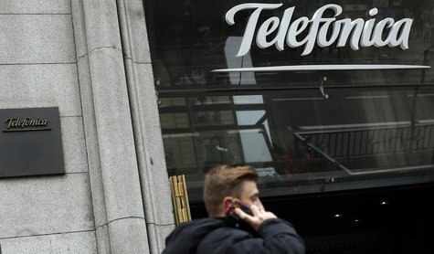 A man talks on a mobile phone as he walks past Spanish telecom group Telefonica flagship store in central Madrid November 8, 2013. REUTERS/S A man talks on a mobile phone as he walks past Spanish telecom group Telefonica flagship store in central Madrid November 8, 2013. REUTERS/S