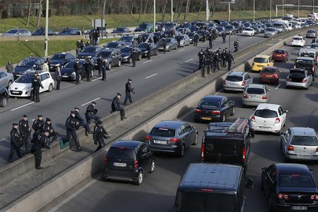 French gendarmes secure the Paris ring road as taxi drivers on strike block the traffic during a protest in Paris February 10, 2014. REUTERS French gendarmes secure the Paris ring road as taxi drivers on strike block the traffic during a protest in Paris February 10, 2014. REUTERS