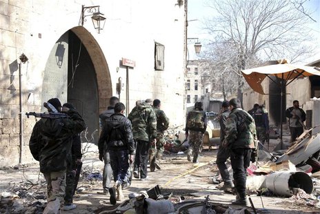 Forces loyal to Syria's President Bashar al-Assad carry their weapons as they walk along a street in the old city of Aleppo, February 10, 20 Forces loyal to Syria's President Bashar al-Assad carry their weapons as they walk along a street in the old city of Aleppo, February 10, 20