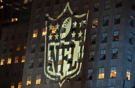 A man stands at a window lit by the NFL logo as he watches performances during the 2012 NFL kickoff show in New York September 5, 2012. REUT A man stands at a window lit by the NFL logo as he watches performances during the 2012 NFL kickoff show in New York September 5, 2012. REUT