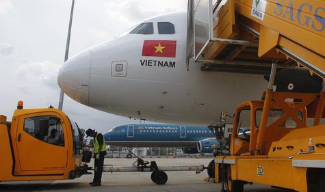 A worker pumps fuel into a Vietjet Air A320 aircraft, in front of a Vietnam Airlines aircraft at Tan Son Nhat airport in Vietnam's southern A worker pumps fuel into a Vietjet Air A320 aircraft, in front of a Vietnam Airlines aircraft at Tan Son Nhat airport in Vietnam's southern