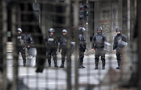 Members of special police are seen through a burned shop during a protest on a blocked street in Sarajevo February 10, 2014. REUTERS/Dado Ru Members of special police are seen through a burned shop during a protest on a blocked street in Sarajevo February 10, 2014. REUTERS/Dado Ru