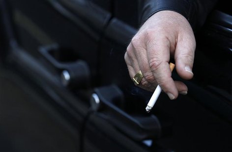 A man smokes in his car in London November 16, 2011. REUTERS/Suzanne Plunkett A man smokes in his car in London November 16, 2011. REUTERS/Suzanne Plunkett