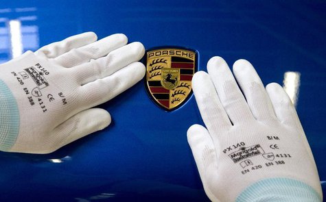 A man does the final touches on the Porsche logo of a Macan at the new plant in the eastern German city of Leipzig February 5, 2014. REUTERS A man does the final touches on the Porsche logo of a Macan at the new plant in the eastern German city of Leipzig February 5, 2014. REUTERS