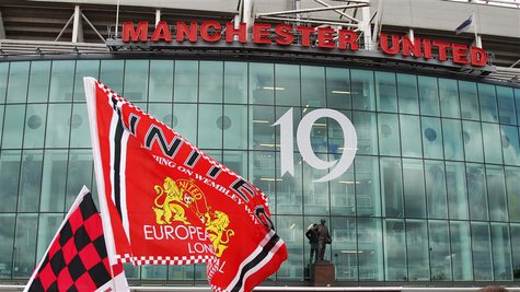 Manchester United supporters wave flags outside the stadium before their English Premier League soccer match against Blackpool at Old Traffo Manchester United supporters wave flags outside the stadium before their English Premier League soccer match against Blackpool at Old Traffo