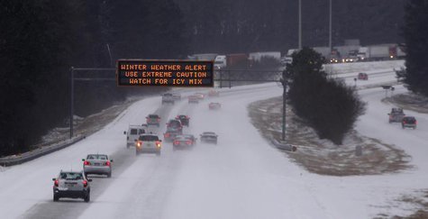 Cars drive under a traffic sign displaying winter storm warnings after a rare snowstorm in Kennesaw, Georgia, January 28, 2014. REUTERS/Tami Cars drive under a traffic sign displaying winter storm warnings after a rare snowstorm in Kennesaw, Georgia, January 28, 2014. REUTERS/Tami