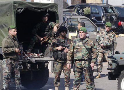 Lebanese army soldiers stand near a booby-trapped car (black, in background) loaded with explosives in the Corniche al-Mazraa district of ce Lebanese army soldiers stand near a booby-trapped car (black, in background) loaded with explosives in the Corniche al-Mazraa district of ce