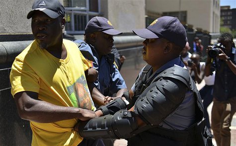 A police officer detains an African National Congress (ANC) supporter after they tried to confront members of the opposition Democratic Alli A police officer detains an African National Congress (ANC) supporter after they tried to confront members of the opposition Democratic Alli