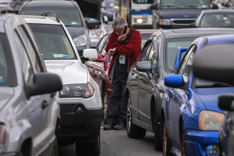 A man looks at his watch while waiting for hours to get fuel from a gas station in the New York City borough of Queens on November 1, 2012. A man looks at his watch while waiting for hours to get fuel from a gas station in the New York City borough of Queens on November 1, 2012.
