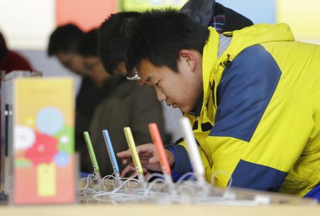 A customer tests an iPhone 5C at an Apple store in Beijing January 17, 2014. REUTERS/Jason Lee A customer tests an iPhone 5C at an Apple store in Beijing January 17, 2014. REUTERS/Jason Lee