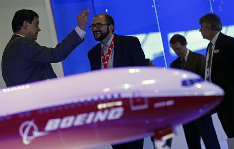 Visitors talk next to a Boeing 777X aircraft model at the Singapore Airshow February 13, 2014. REUTERS/Edgar Su Visitors talk next to a Boeing 777X aircraft model at the Singapore Airshow February 13, 2014. REUTERS/Edgar Su