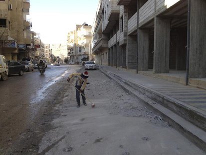 A boy cleans debris near buildings damaged by what activists said were shelling by forces loyal to President Bashar al-Assad, at Yabroud, ne A boy cleans debris near buildings damaged by what activists said were shelling by forces loyal to President Bashar al-Assad, at Yabroud, ne
