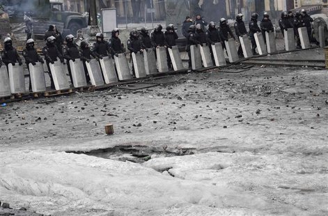 Riot police stand guard near barricades built at the site of recent clashes with anti-government protesters in Kiev February 13, 2014. REUTE Riot police stand guard near barricades built at the site of recent clashes with anti-government protesters in Kiev February 13, 2014. REUTE