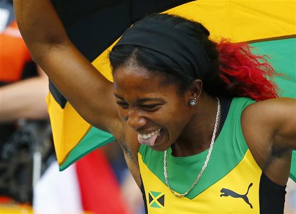 Shelly-Ann Fraser-Pryce of Jamaica holds her national flag after winning the women's 4x100 metres relay final during the IAAF World Athletic Shelly-Ann Fraser-Pryce of Jamaica holds her national flag after winning the women's 4x100 metres relay final during the IAAF World Athletic