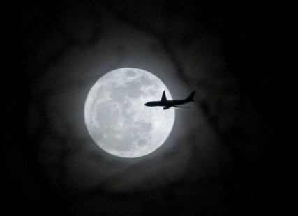 A plane passes in front of a full moon over New York City February 17, 2011. REUTERS/Eric Thayer A plane passes in front of a full moon over New York City February 17, 2011. REUTERS/Eric Thayer