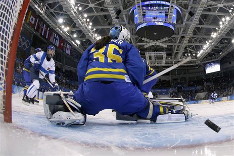 Finland's Emma Nuutinen (L) shoots past Sweden's goalie Valentina Wallner to score during the third period of their women's ice hockey playo Finland's Emma Nuutinen (L) shoots past Sweden's goalie Valentina Wallner to score during the third period of their women's ice hockey playo