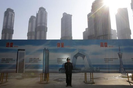 A security guard stands next to an advertising board in front of a residential compound under construction in Wuhan, Hubei province January A security guard stands next to an advertising board in front of a residential compound under construction in Wuhan, Hubei province January