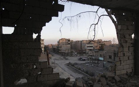 Free Syrian Army fighters stand along a damaged street as they are seen through a hole of a damaged wall in Deir al-Zor, eastern Syria Febru Free Syrian Army fighters stand along a damaged street as they are seen through a hole of a damaged wall in Deir al-Zor, eastern Syria Febru