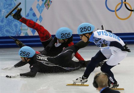 Canada's Charles Hamelin (back) and Eduardo Alvarez of the U.S. (front) fall as Russia's Victor An (R) skates past during the men's 1,000 me Canada's Charles Hamelin (back) and Eduardo Alvarez of the U.S. (front) fall as Russia's Victor An (R) skates past during the men's 1,000 me