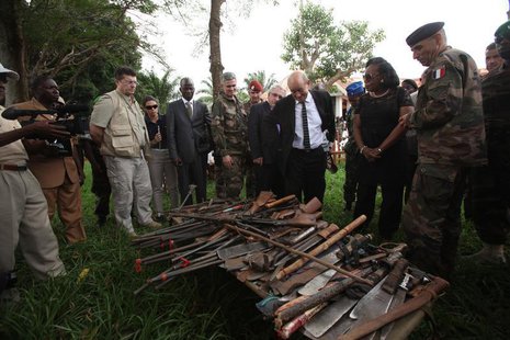 French Defense Minister Jean Yves-Le Drian (C) and Central African Republic's interim President Catherine Samba Panza (2nd R) look at seized French Defense Minister Jean Yves-Le Drian (C) and Central African Republic's interim President Catherine Samba Panza (2nd R) look at seized