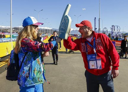 A fan (R) greets Yuliya Udalykh, a volunteer from the Urals city of Yekaterinburg, at the entrance to the Olympic Park during the Sochi 2014 A fan (R) greets Yuliya Udalykh, a volunteer from the Urals city of Yekaterinburg, at the entrance to the Olympic Park during the Sochi 2014