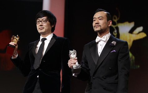 Diao Yinan (L) director of "Bai Ri Yan Huo" (Black Coal, Thin Ice) poses with his Golden Bear for Best Film next to actor Liao Fan (R) who p Diao Yinan (L) director of "Bai Ri Yan Huo" (Black Coal, Thin Ice) poses with his Golden Bear for Best Film next to actor Liao Fan (R) who p
