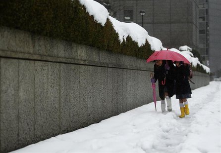 School children share an umbrella on a street covered by snow near the Bank of Japan building in Tokyo February 15, 2014. REUTERS/Yuya Shino School children share an umbrella on a street covered by snow near the Bank of Japan building in Tokyo February 15, 2014. REUTERS/Yuya Shino