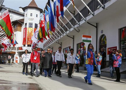 Members of India's national athletes team walk to attend the welcoming ceremony for the team in the Olympic athlete's village, which stands Members of India's national athletes team walk to attend the welcoming ceremony for the team in the Olympic athlete's village, which stands