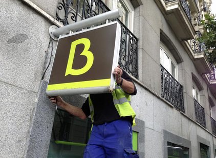 A worker puts in place a Bankia logo at a Bankia branch in Madrid May 20, 2013. REUTERS/Juan Medina A worker puts in place a Bankia logo at a Bankia branch in Madrid May 20, 2013. REUTERS/Juan Medina