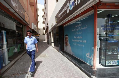 A man walks past a Du telecommunications advertisement in Deira in Dubai March 12, 2012. REUTERS/Jumana El Heloueh A man walks past a Du telecommunications advertisement in Deira in Dubai March 12, 2012. REUTERS/Jumana El Heloueh