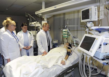Russia's President Vladimir Putin (R) visits Russian Olympic skicross racer Maria Komissarova at a hospital in Sochi, February 15, 2014. REU Russia's President Vladimir Putin (R) visits Russian Olympic skicross racer Maria Komissarova at a hospital in Sochi, February 15, 2014. REU