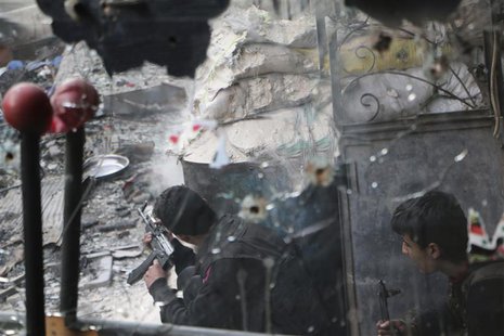 A Free Syrian Army fighter, seen through a mirror riddled with bullets, fires his weapon towards forces loyal to Syria's President Bashar al A Free Syrian Army fighter, seen through a mirror riddled with bullets, fires his weapon towards forces loyal to Syria's President Bashar al