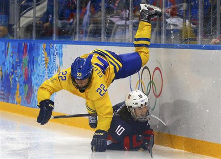 Sweden's Emma Eliasson falls over Team USA's Meghan Duggan during the third period of their women's semi-final ice hockey game at the 2014 S Sweden's Emma Eliasson falls over Team USA's Meghan Duggan during the third period of their women's semi-final ice hockey game at the 2014 S