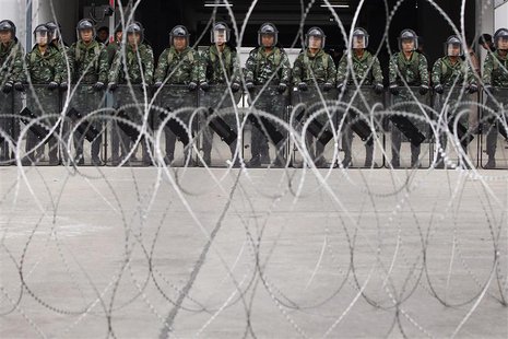 Soldiers hold their shields as they guard the temporary office of Thai Prime Minister Yingluck Shinawatra during a protest in Bangkok Februa Soldiers hold their shields as they guard the temporary office of Thai Prime Minister Yingluck Shinawatra during a protest in Bangkok Februa