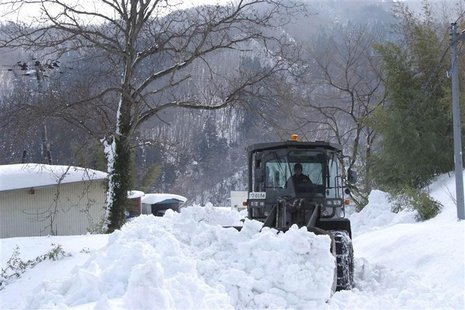 A loader of the Japan Ground Self-Defence Force removes snow covering a public road in Marumori town, Miyagi prefecture, in this handout pic A loader of the Japan Ground Self-Defence Force removes snow covering a public road in Marumori town, Miyagi prefecture, in this handout pic