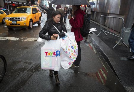 A woman carries bags of purchases though Times Square in New York, December 23, 2013. REUTERS/Carlo Allegri A woman carries bags of purchases though Times Square in New York, December 23, 2013. REUTERS/Carlo Allegri